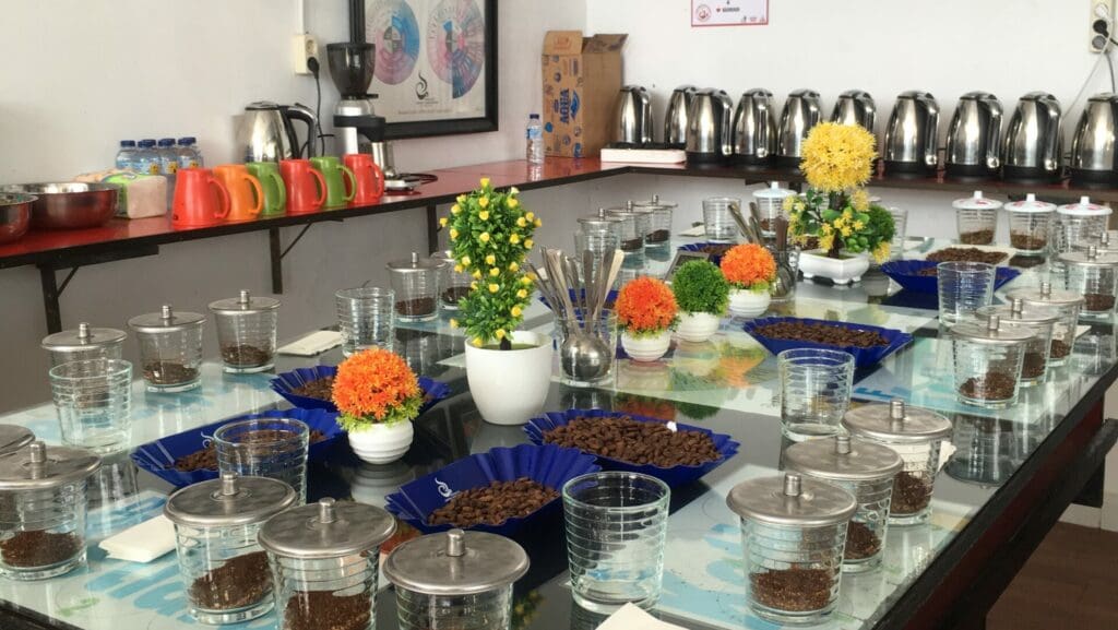 glass cups set around the edge of a glass table with flowers in the middle