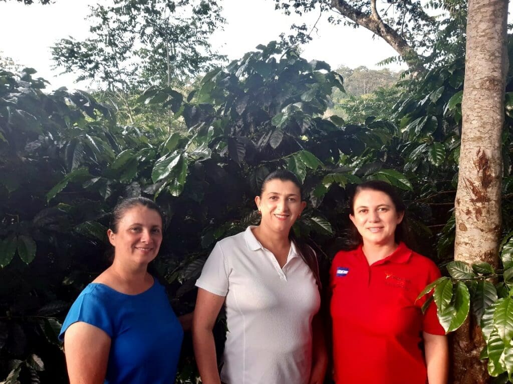 ree smiling women with thick foliage in the background